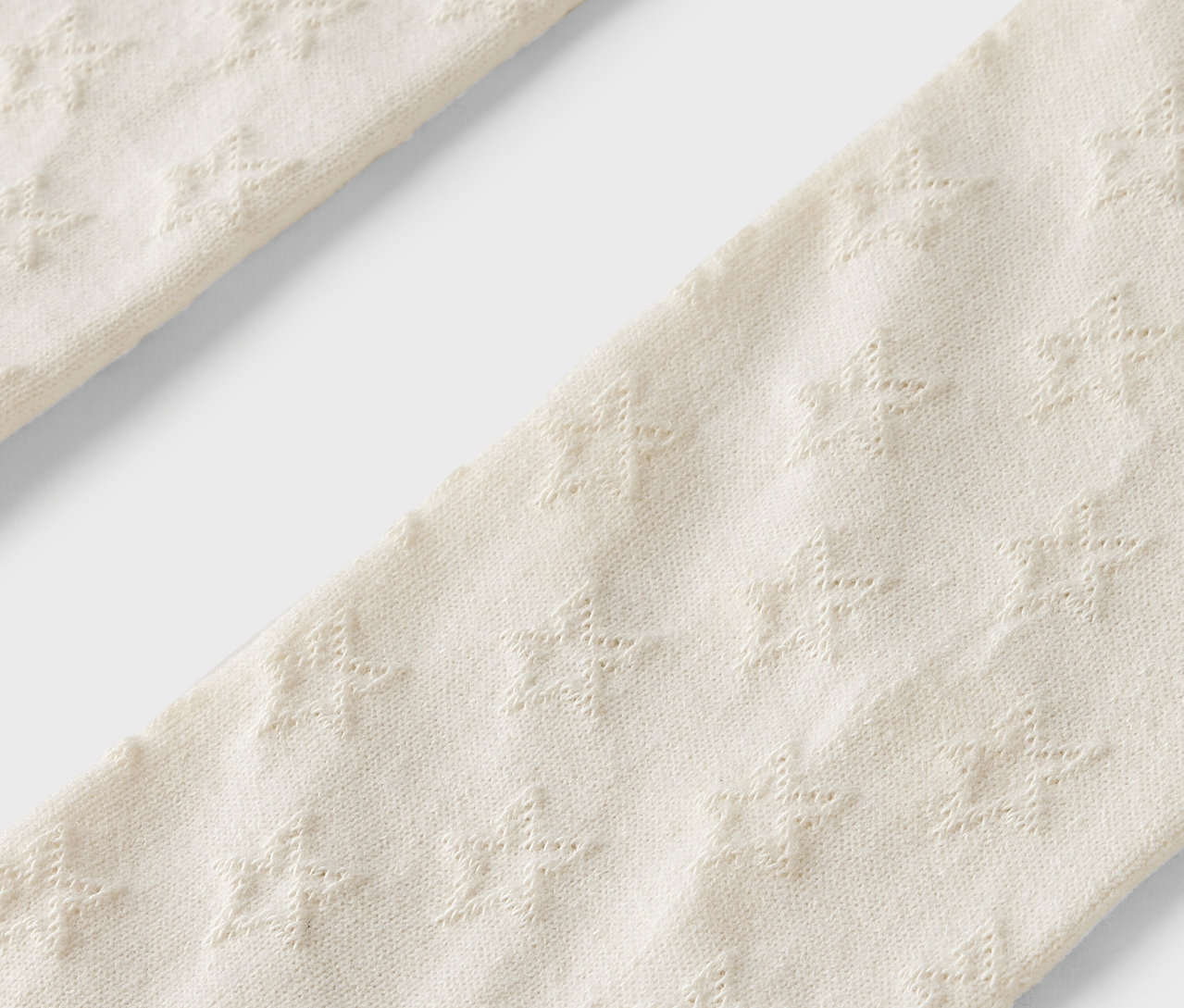 Gros plan sur un collant beige à motif étoilé.