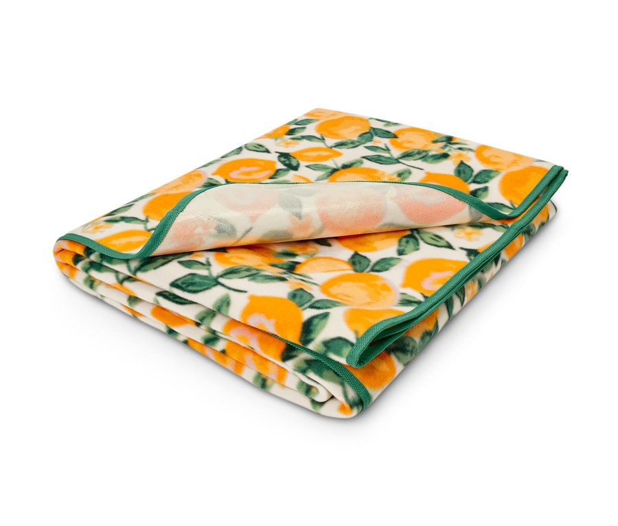 Nappe de pique-nique XL pliée avec un motif floral orange et une bordure verte.