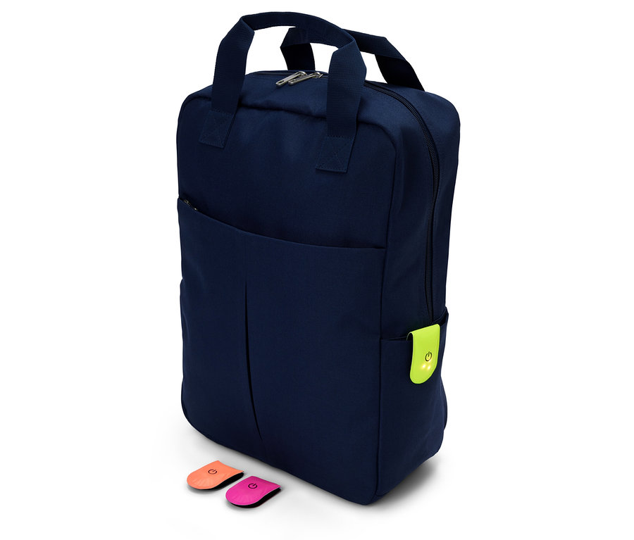 Un sac à dos bleu marine avec une étiquette vert néon et deux badges colorés sur fond blanc.