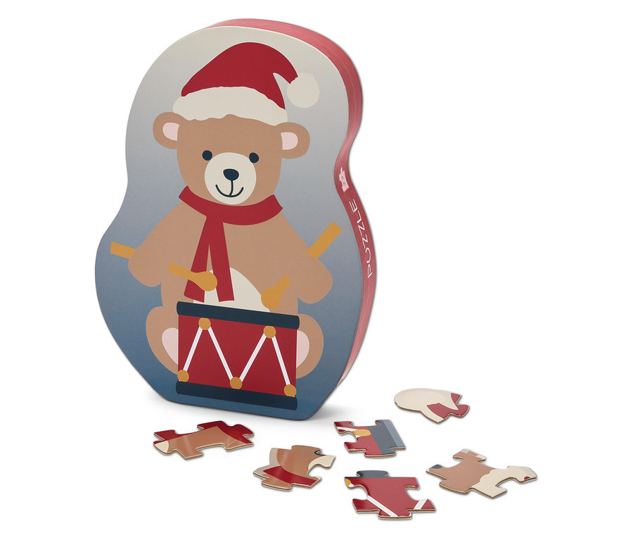 Boîte de puzzle avec un ours jouant du tambour avec un bonnet de Noël et six pièces de puzzle.