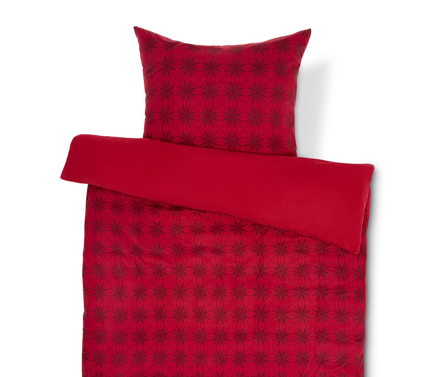 Linge de lit rouge avec motif de flocons de neige rouge foncé et oreiller.