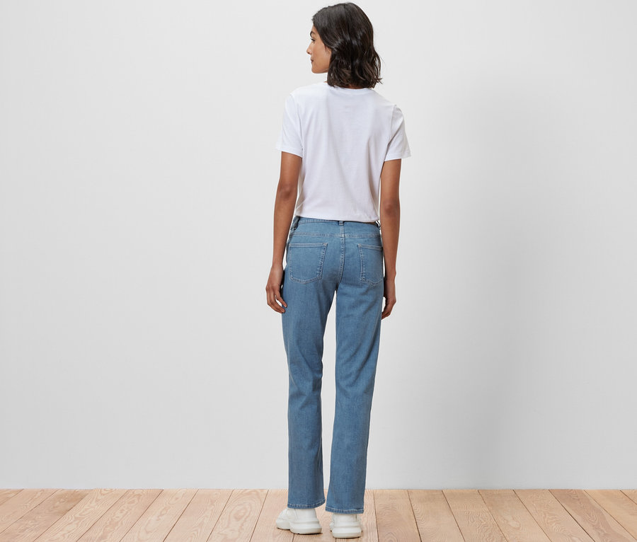 Une femme, vue de dos, porte un jean droit - Coupe « Kira » et un t-shirt blanc.