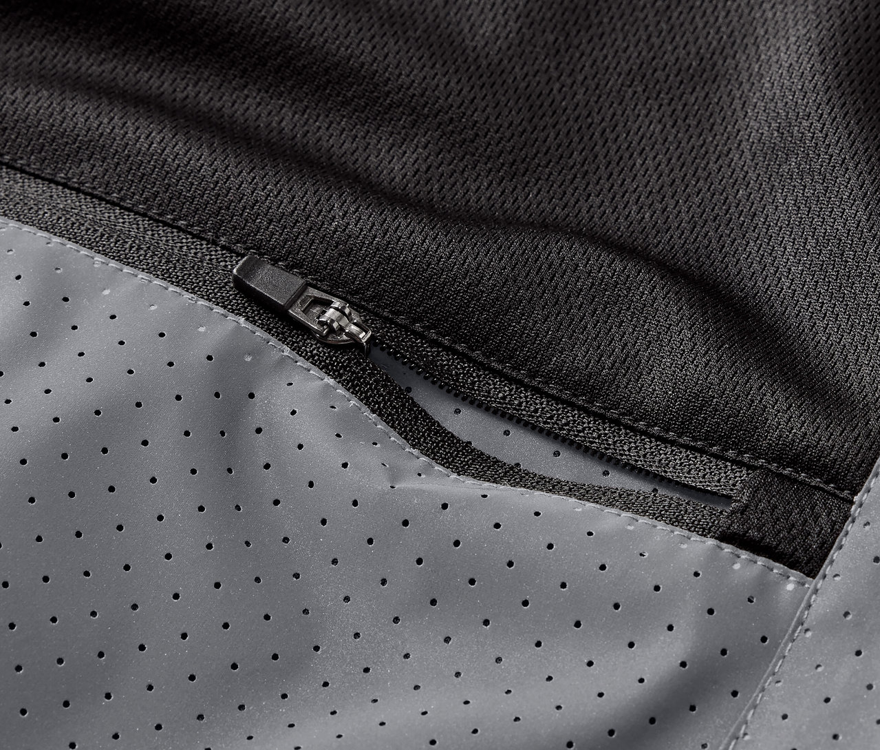 Gros plan sur la poche zippée d'un gilet de course réfléchissant.