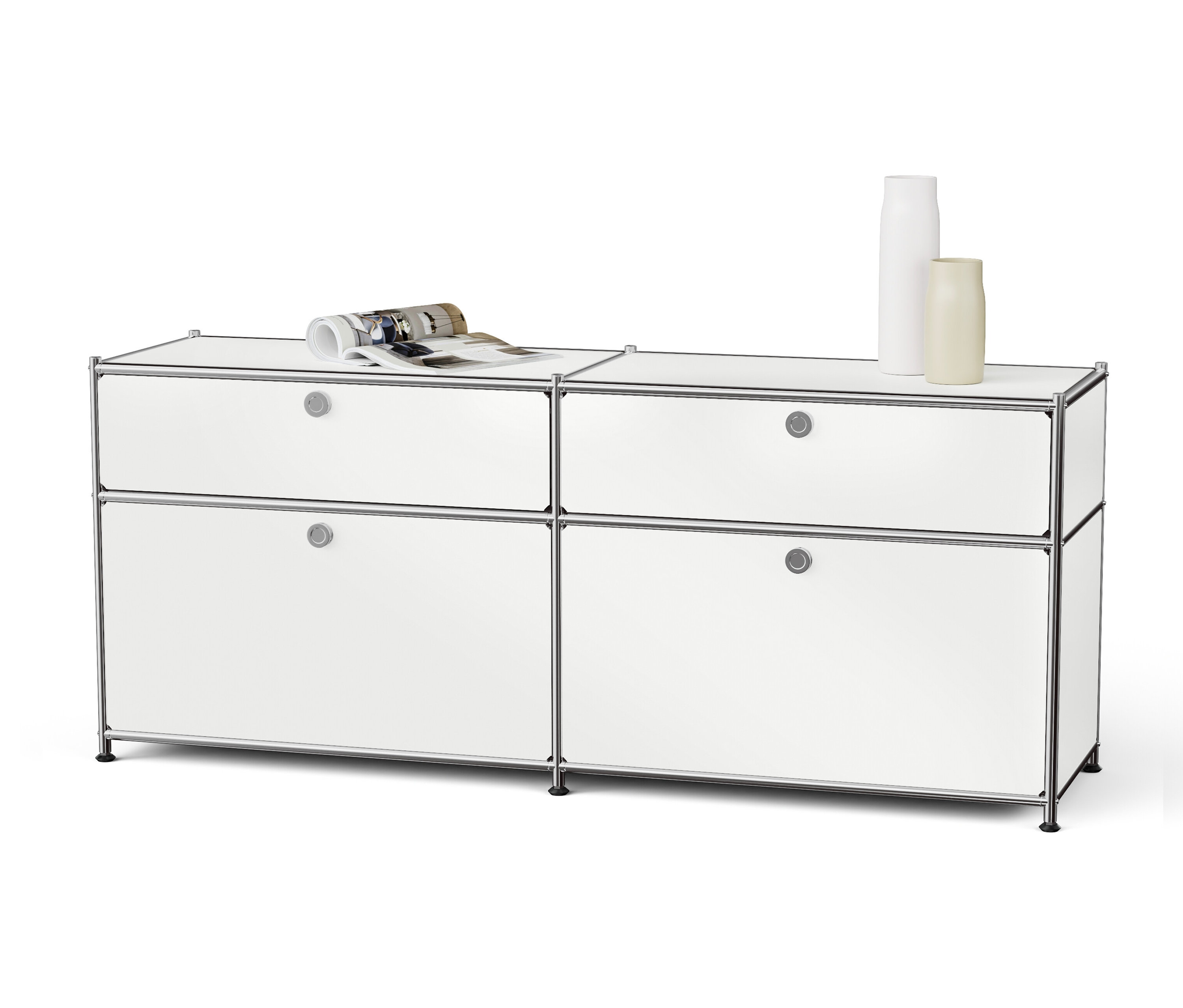 Système de rangement modulaire blanc avec quatre tiroirs et cadre en acier. Un magazine ouvert et deux vases sont posés sur le dessus.