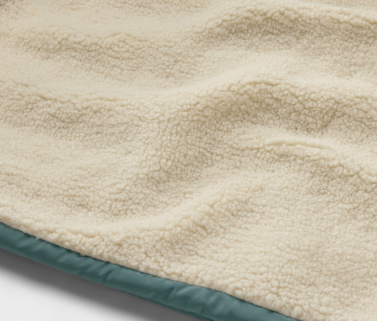 Détail d'un gilet sans manches matelassé en teddy pour enfant.