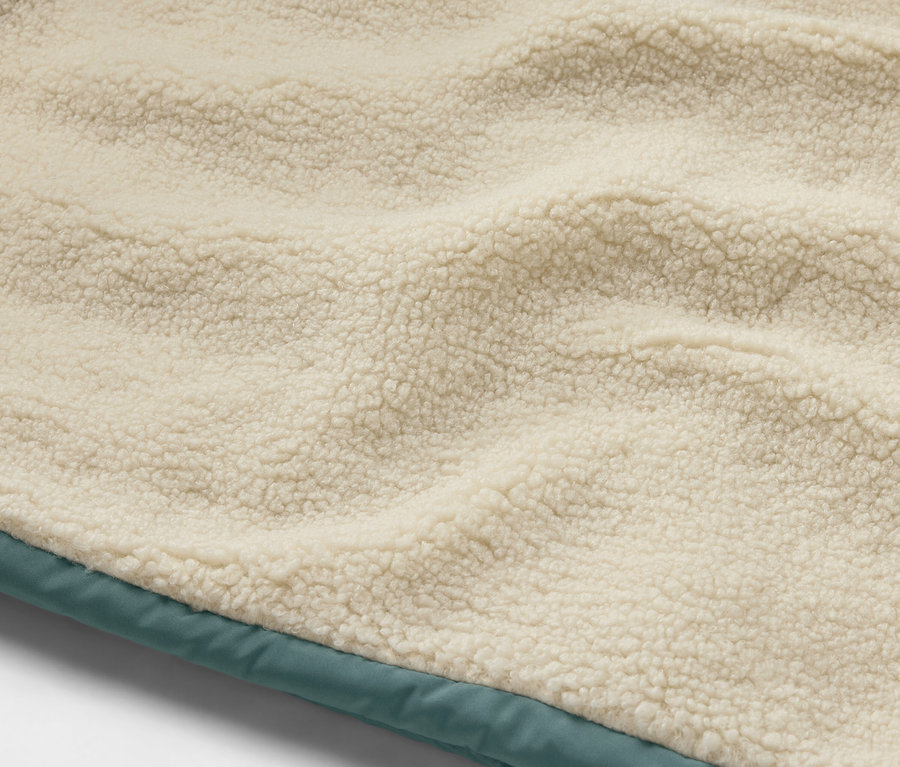 Détail d'un gilet sans manches matelassé en teddy pour enfant.