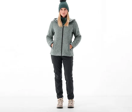 Femme debout portant un pantalon softshell CMP, une veste et un bonnet.