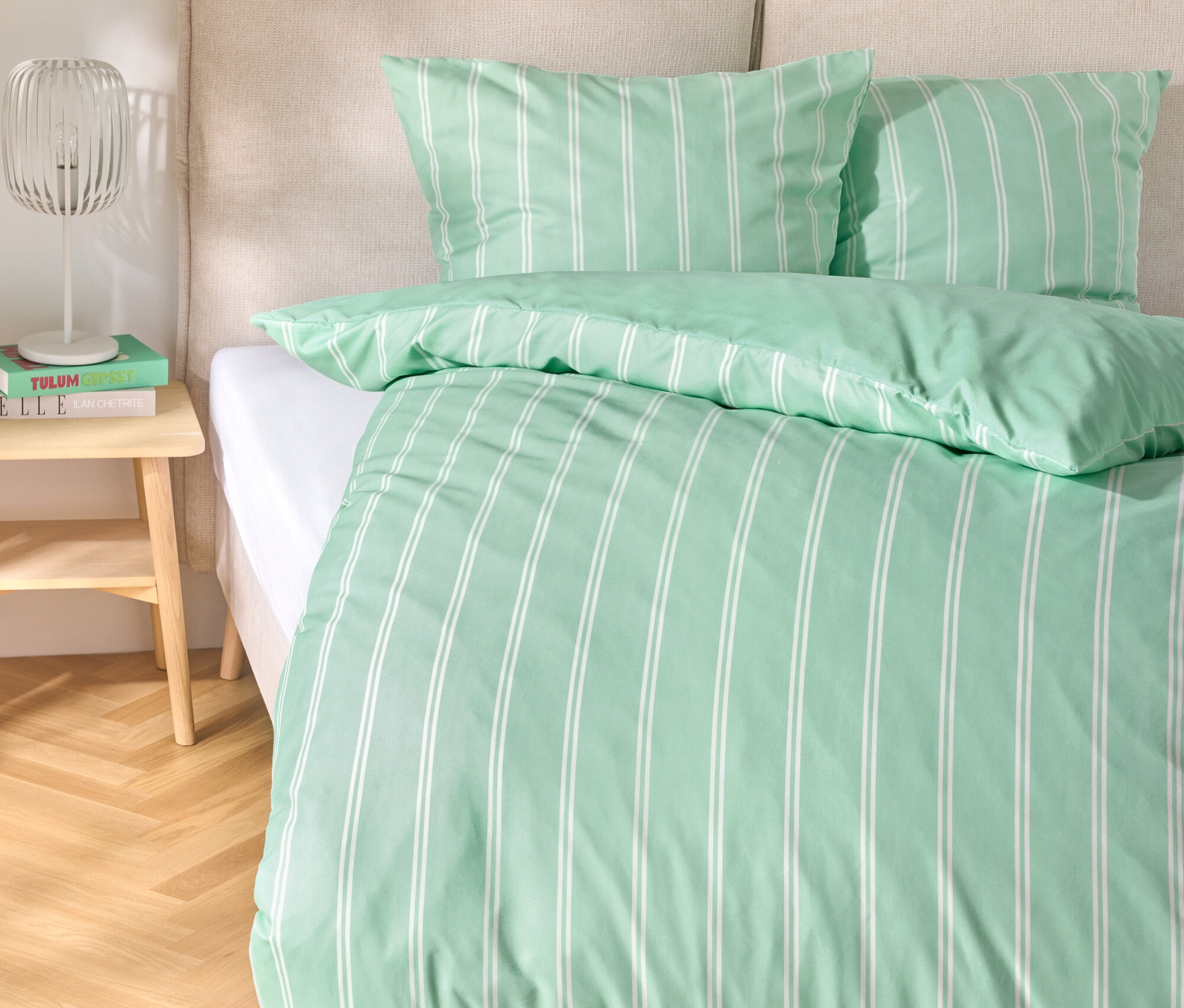 Lit avec linge de lit en microfibre vert clair, taille standard et king size, avec des rayures blanches.