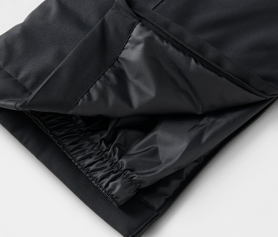 Détail d'un pantalon noir avec fermeture éclair ouverte et couche intérieure.