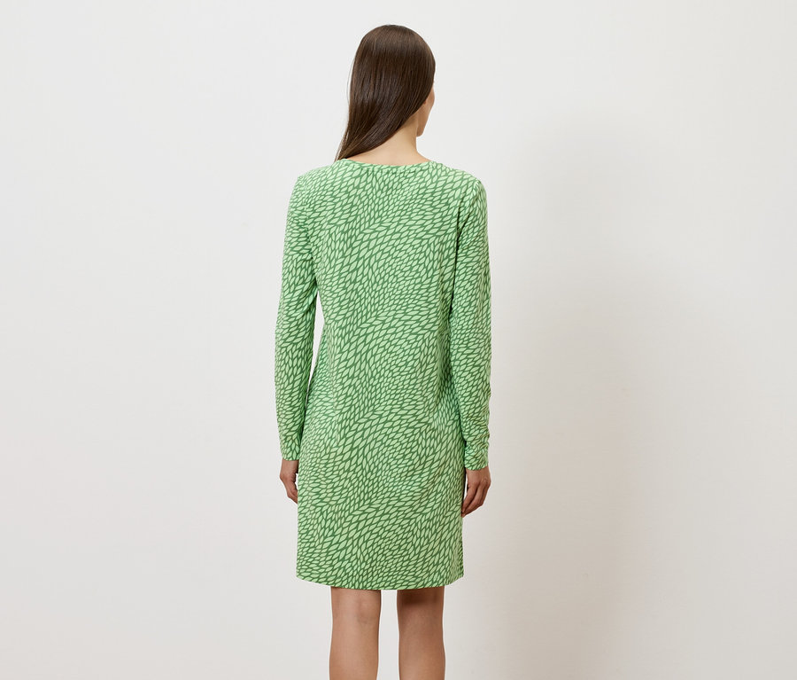 Vue de dos d'une femme portant une robe verte à manches longues.