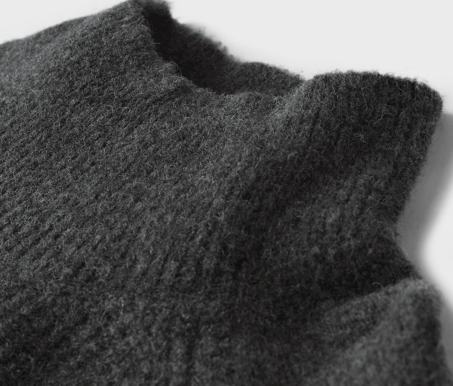 Gros plan sur la texture d'un pull gris.
