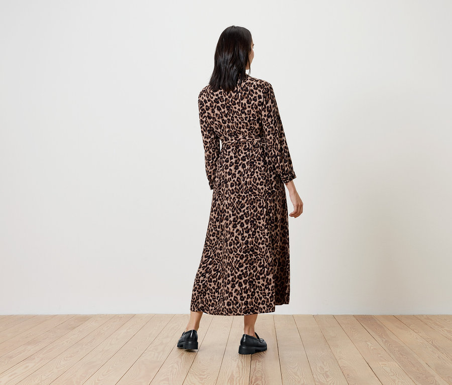 Femme portant une longue robe à motif animalier, dos à la caméra.