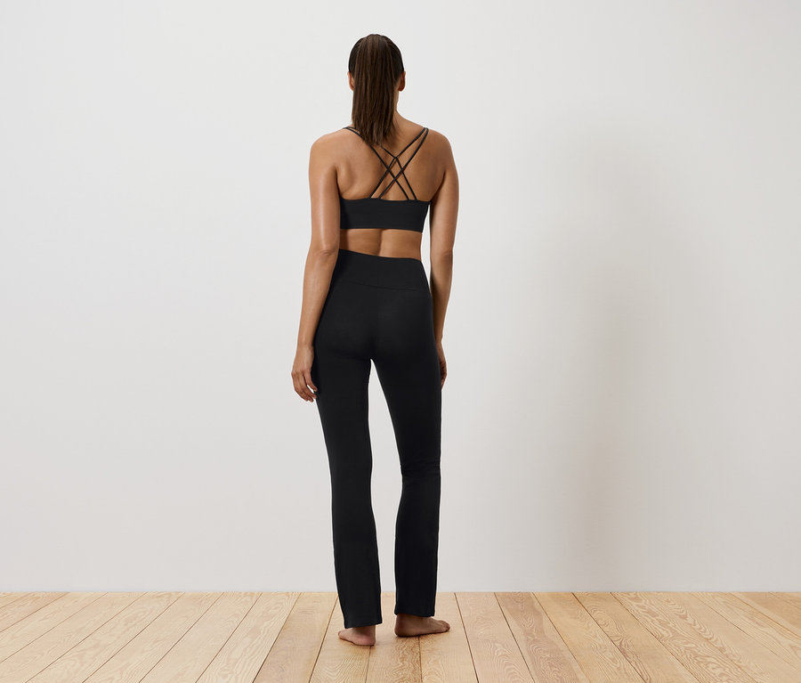 Femme en tenue de sport noire, vue de dos.