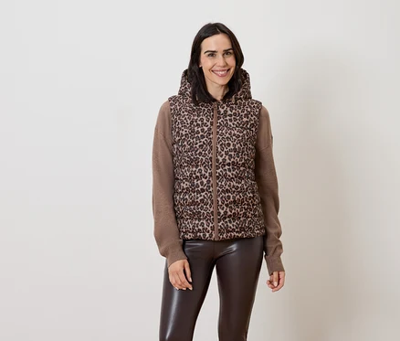 Femme posant dans un gilet marron à capuche à motif animal et un pantalon en cuir marron.