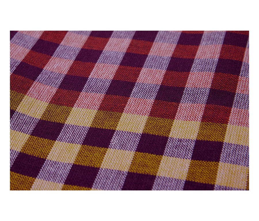 Gros plan d'un tissu à carreaux dans les tons violet, rouge et jaune.