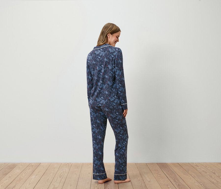 Une femme, vue de dos, porte un pyjama bleu marine imprimé.