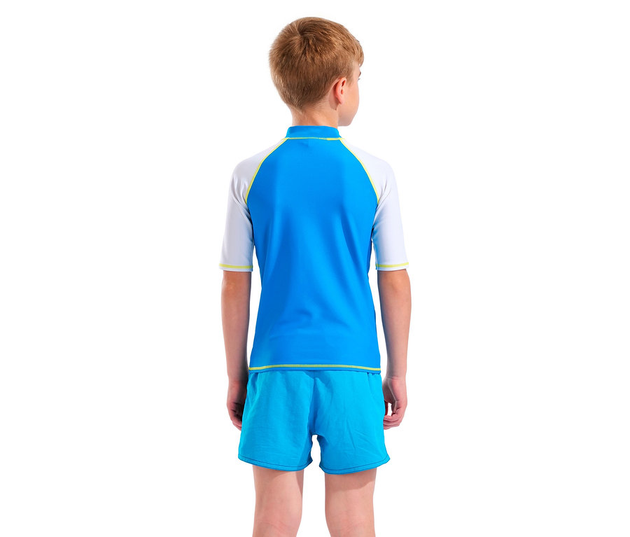 Vue arrière d'un enfant blond portant un rashguard bleu et blanc et un short de bain bleu.