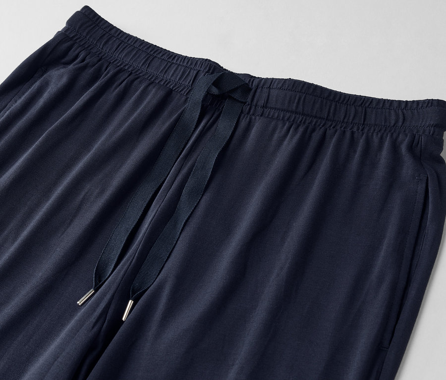 Gros plan sur un pantalon de jogging bleu marine avec cordon de serrage.