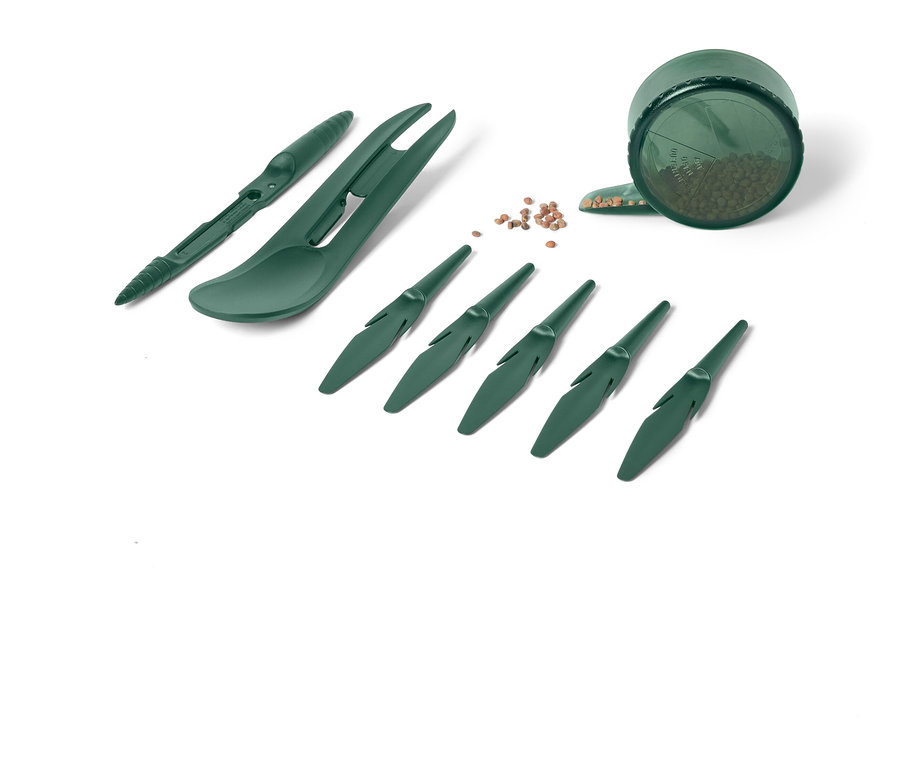 Ensemble d'outils de jardinage verts comprenant des outils de plantation et un récipient avec des graines sur fond blanc.