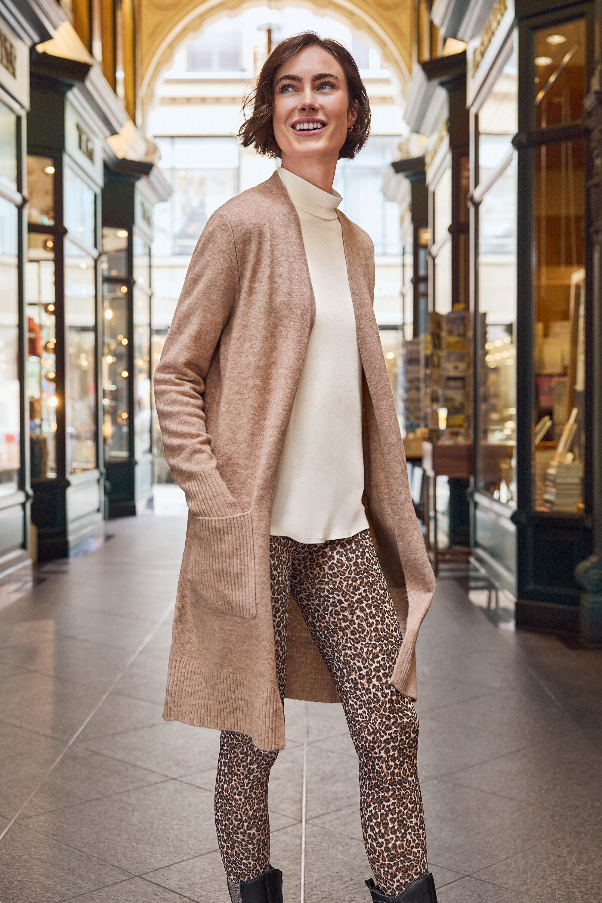 Femme debout dans un bâtiment et portant des créoles hexagonales dorées en argent 925.