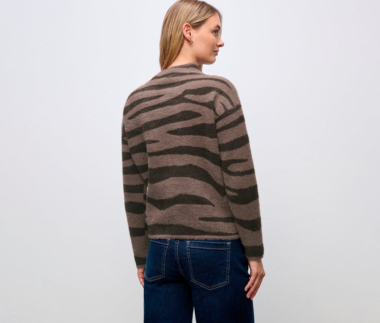 Une femme porte un pull en jacquard Street One et un jean, vue de dos.