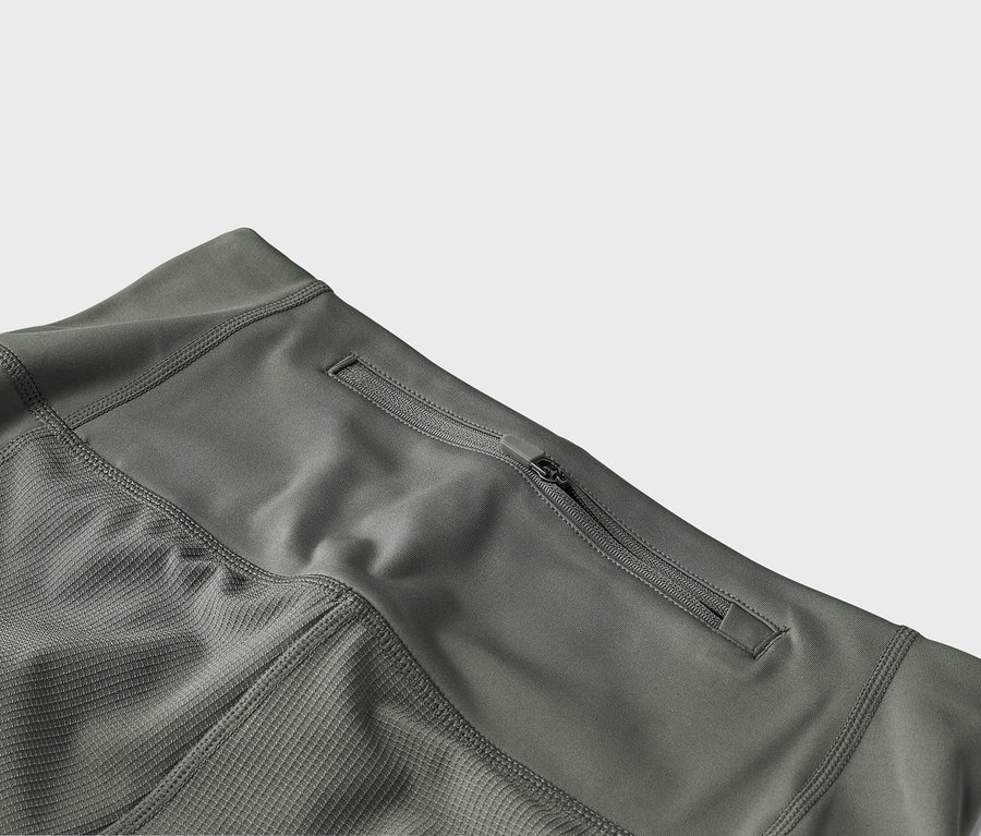 Gros plan d'un pantalon vert olive avec une poche zippée.