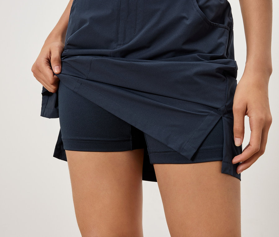 Gros plan d'une femme soulevant une jupe bleu marine avec un short en dessous.