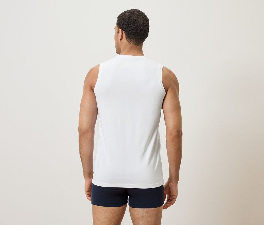 Homme vu de dos, portant un débardeur blanc et un caleçon boxer bleu.