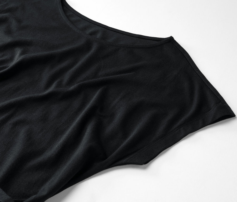 Gros plan d'un t-shirt noir à col rond sur fond blanc.