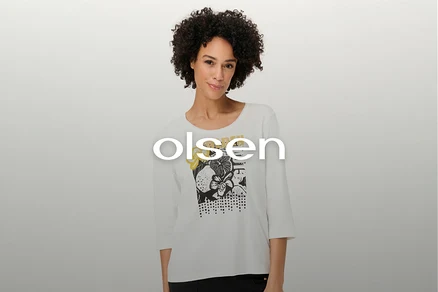 Une femme aux cheveux bouclés porte un t-shirt blanc à manches longues avec un motif floral.