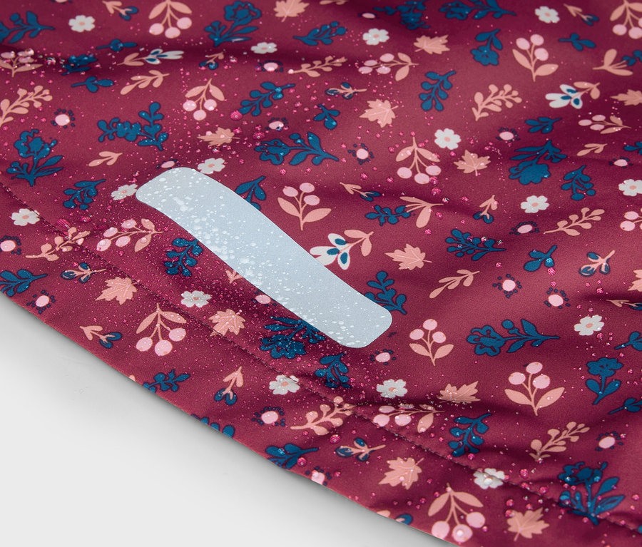 Gros plan d'un tissu bordeaux à motifs floraux avec une bande réfléchissante.