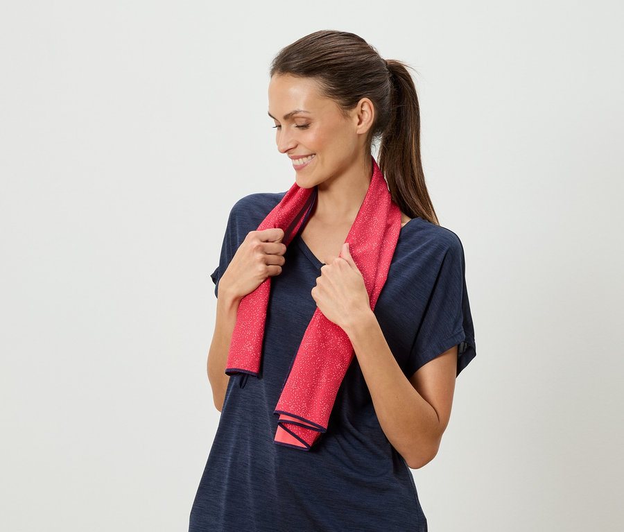 Femme tenant une serviette rouge à pois autour de son cou.