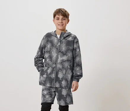 Un jeune homme porte un sweat à capuche à pois et un short assorti.