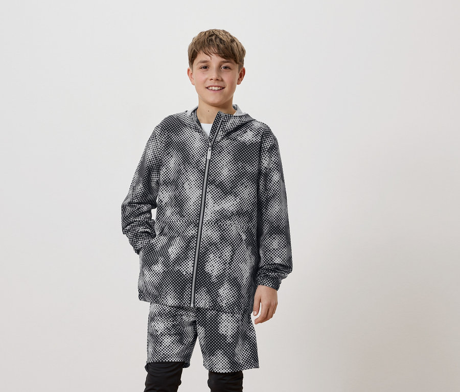 Un jeune homme porte un sweat à capuche à pois et un short assorti.