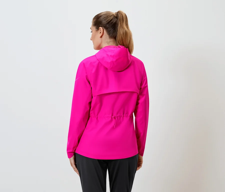 Vue arrière d'une femme portant une veste de pluie rose à capuche et un pantalon noir, les cheveux attachés en queue de cheval, sur fond blanc.