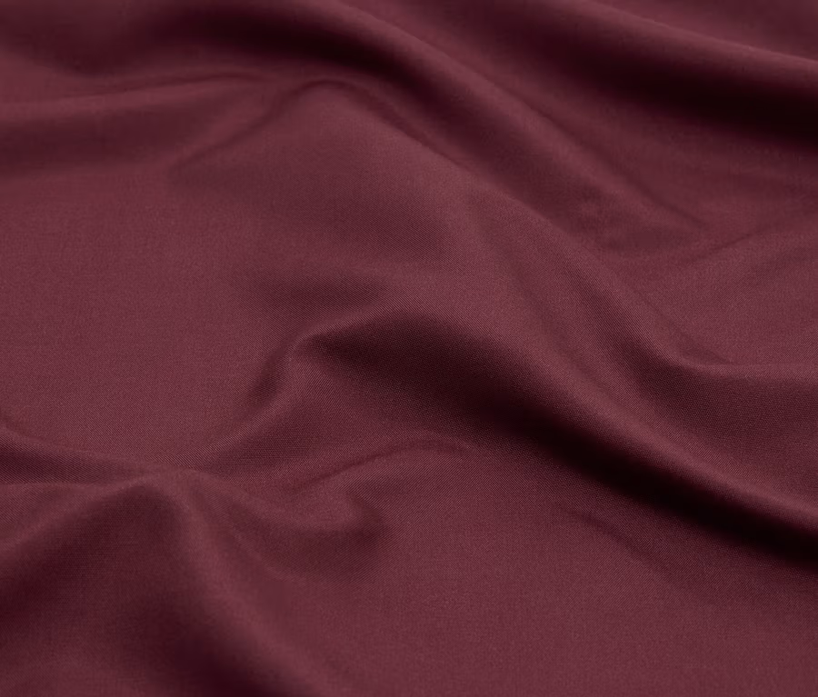 Gros plan d'un tissu bordeaux avec des plis.