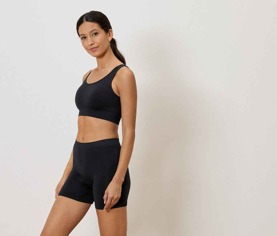 Femme portant un soutien-gorge de sport et un short noirs.