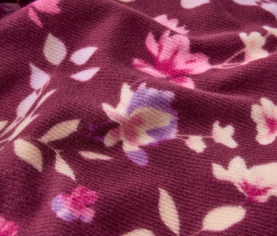 Tissu rouge foncé avec un motif floral rose, violet et crème.
