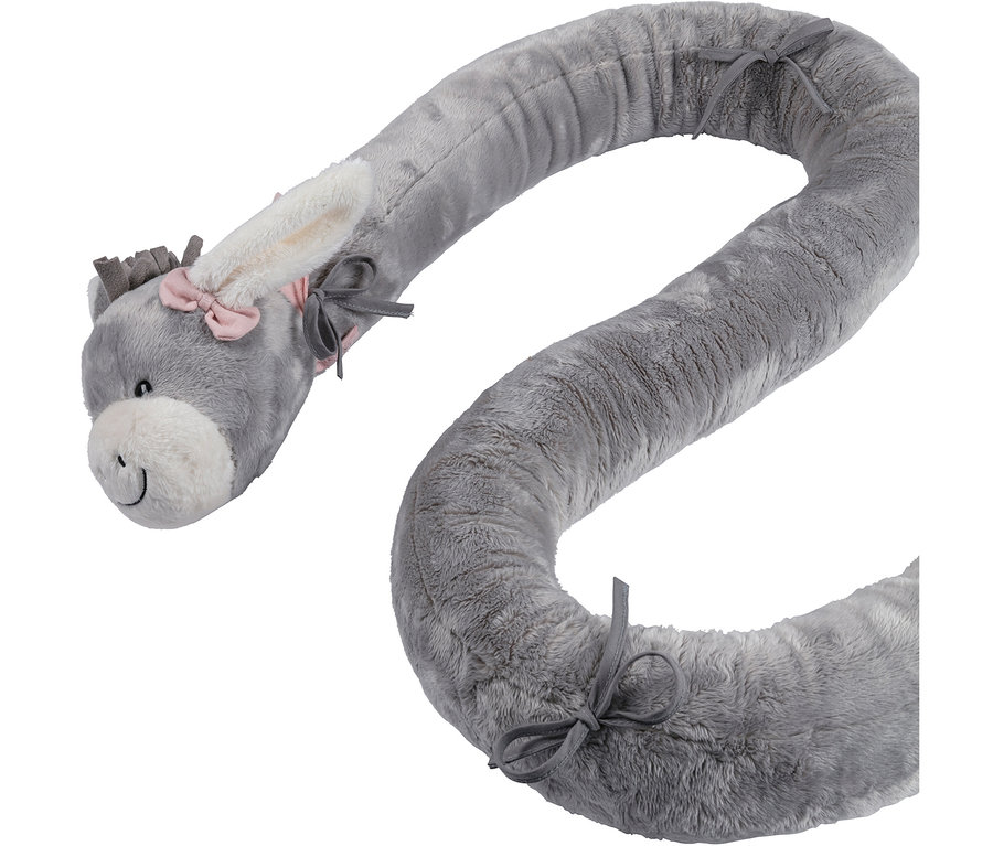 Long boudin de lit en peluche grise en forme d'âne avec un nœud rose sur l'oreille et des liens gris le long du corps.