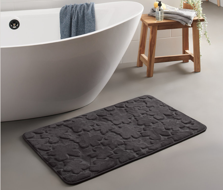 Un tapis de bain confortable noir (env. 60 x 100 cm) est placé à côté d'une baignoire blanche.