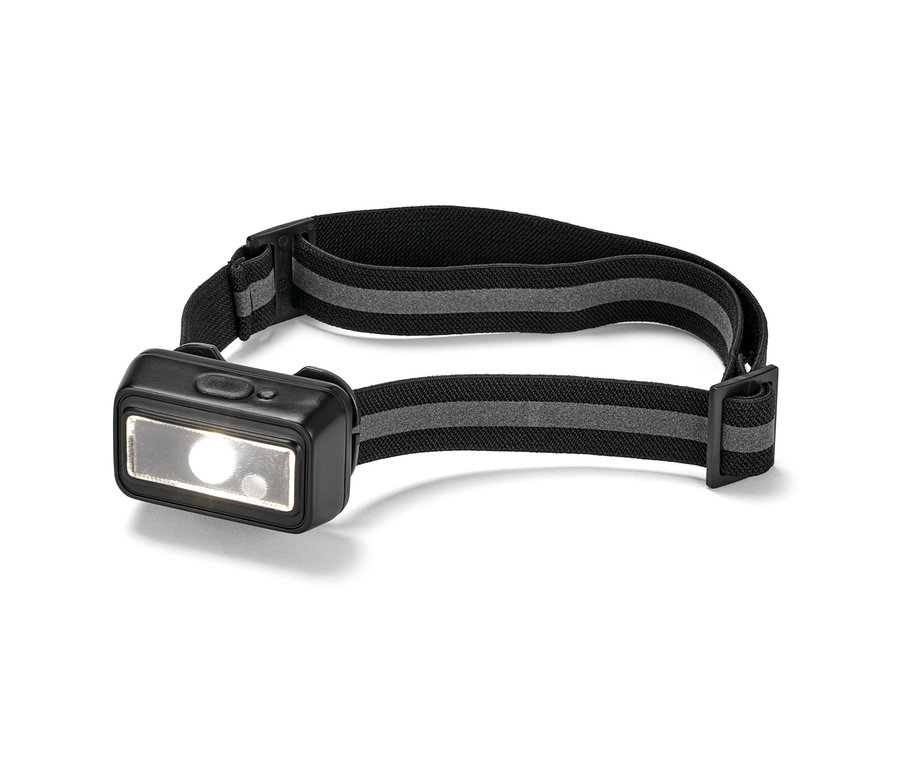 Gros plan d'une lampe frontale compacte avec un bandeau noir et une lumière allumée.