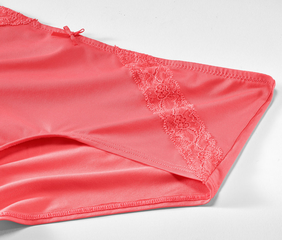 Gros plan sur 2 culottes couleur papaye avec détails en dentelle.