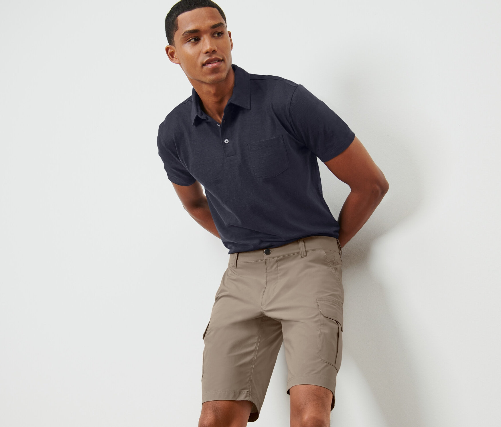Un homme pose en short technique beige.