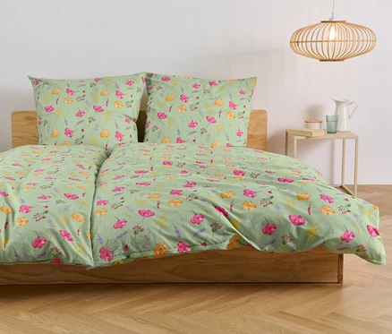 Lit avec parure de lit en microfibre à motif floral.