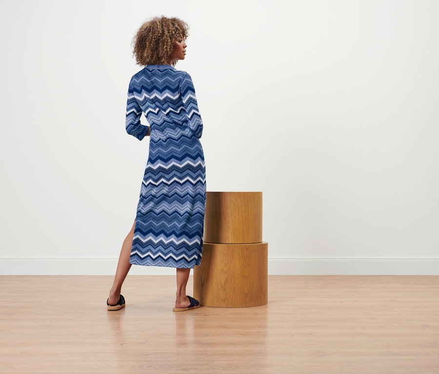 Une femme, dos à la caméra, porte une robe en maille.
