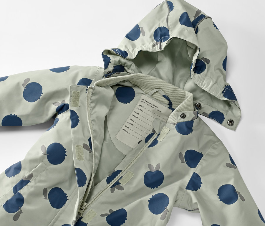 Combinaison de pluie pour tout-petit avec un motif de pommes bleues et une fermeture éclair ouverte.