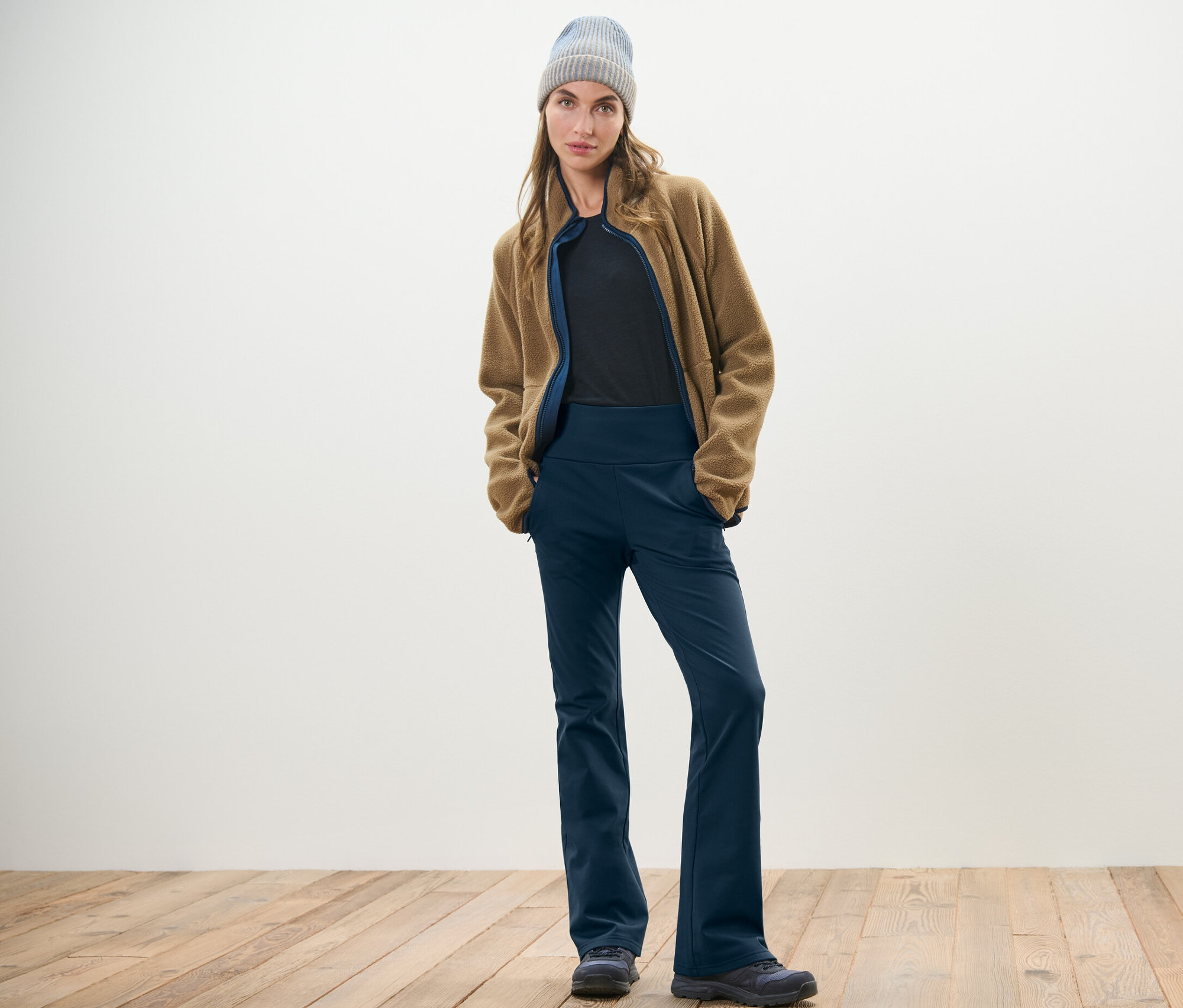Femme posant en pantalon jazz thermique, veste en polaire et bonnet.