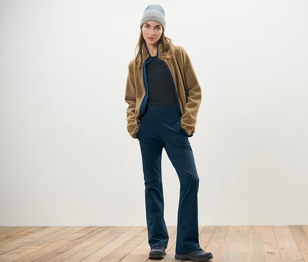Femme posant en pantalon jazz thermique, veste en polaire et bonnet.