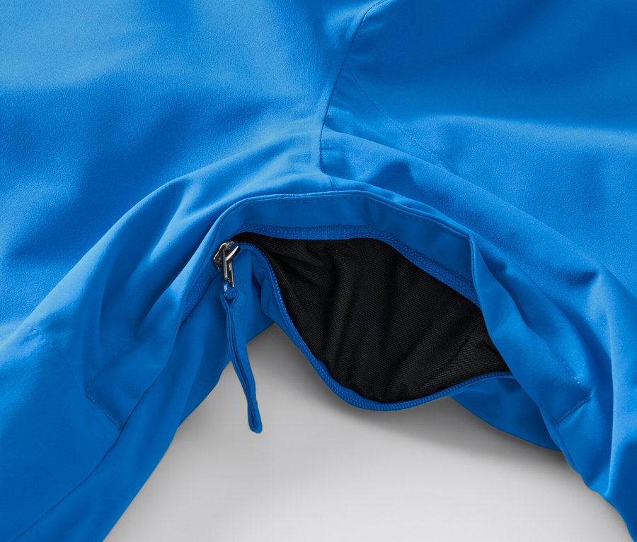 Gros plan sur une veste de ski high-tech bleue avec une poche ouverte.