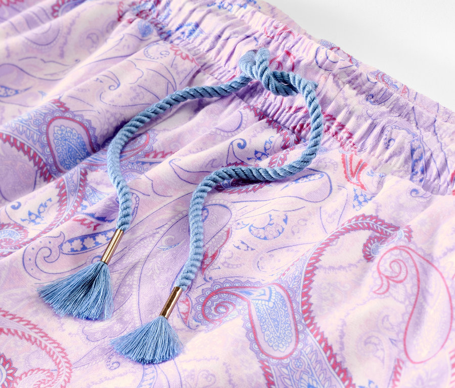 Gros plan d'un pantalon de pyjama à motif cachemire avec un cordon bleu.